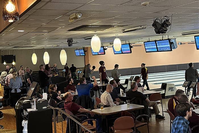 Wide angle photo of OIT staff talking and bowling at Riverwood.