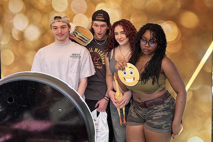 Four students pose in the photobooth.