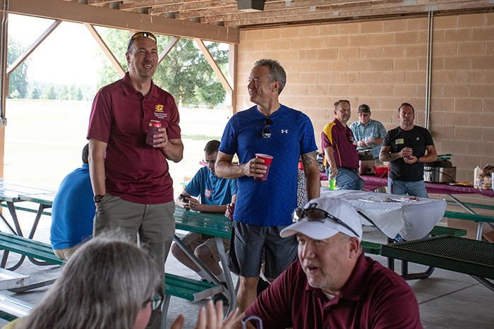 Two staff members share a laugh together.