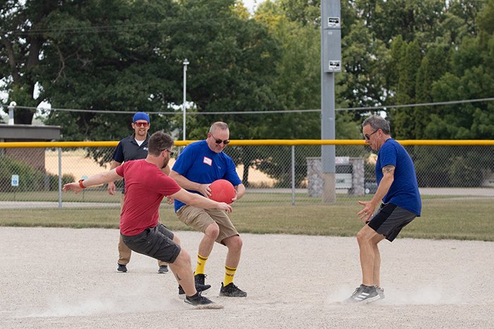A runner and three defensive players race toward second base.