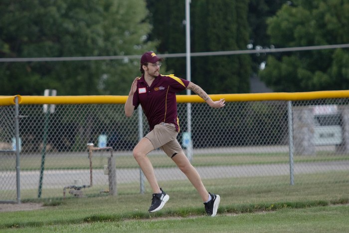 A player races toward home from third base.