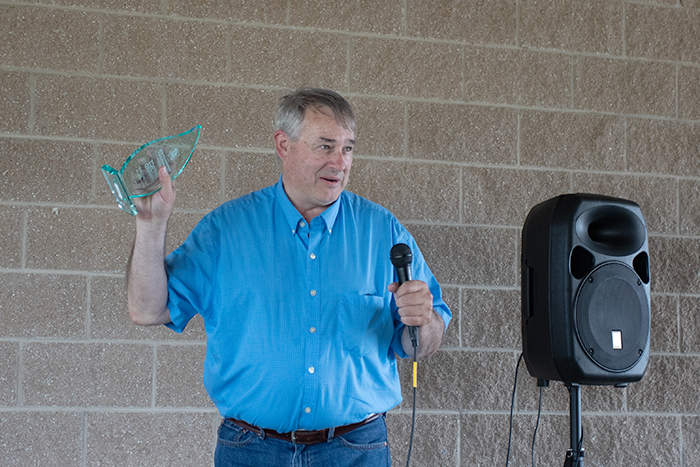 Mark McDonald holds up his award while addressing the audience.
