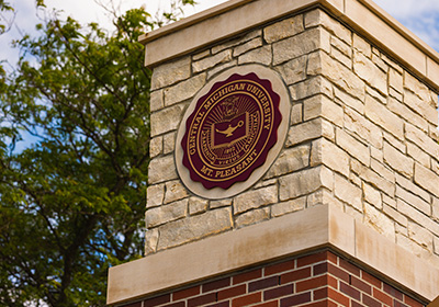 A close up view of the Central Michigan University seal on a stone archway