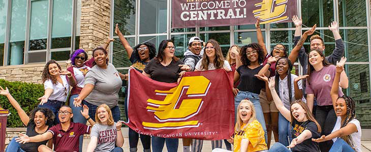 Students in front of the University Center holding CMU flag