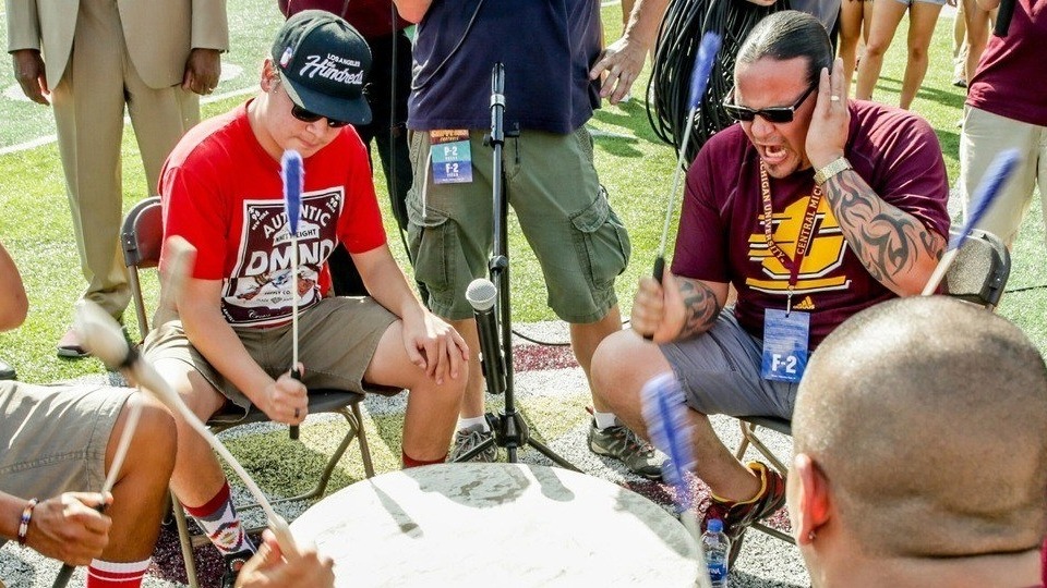 Saginaw Chippewa Indian Tribe A group of people sitting in chairs with microphones in a drum circle.