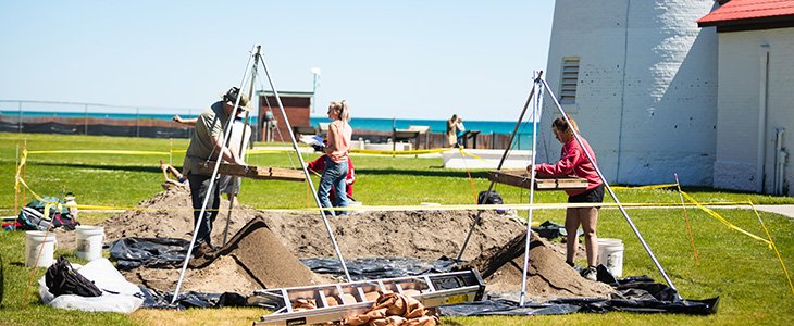 A group of students and faculty work at on a dig site in Fort Gratiot.