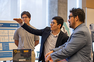 A group of men in suits standing around a table.