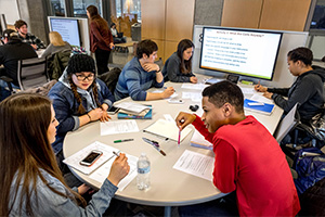 Two students work together at a table in an active learning classroom.