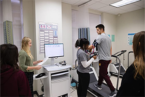 Exercise science students gather data from man on treadmill