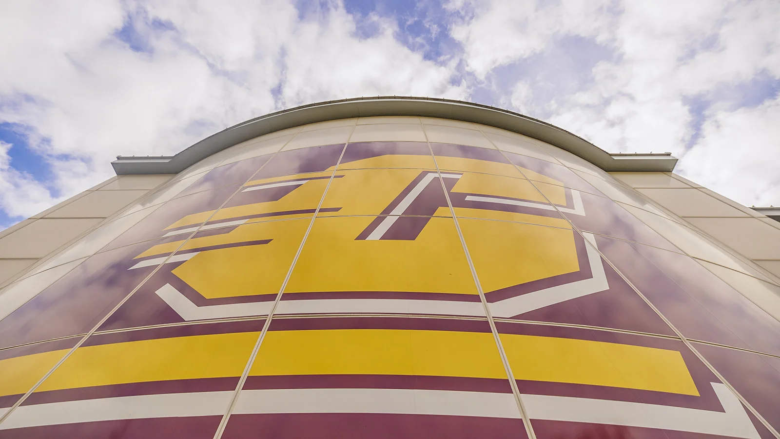 A close up photo of a large maroon and gold Action C building design on Central Michigan University's campus.