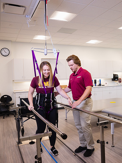 Two physical therapy students demonstrate techniques and exercises.