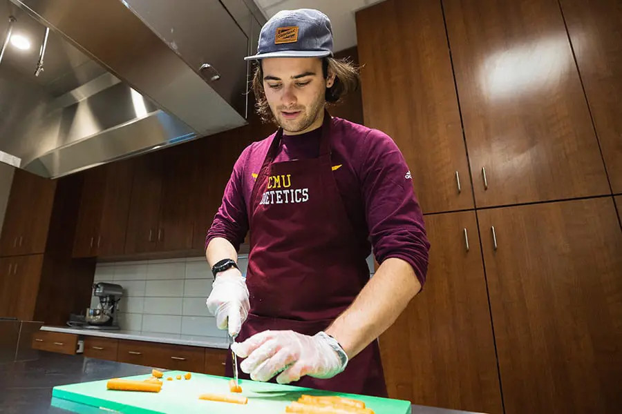 Nutrition student cutting carrots