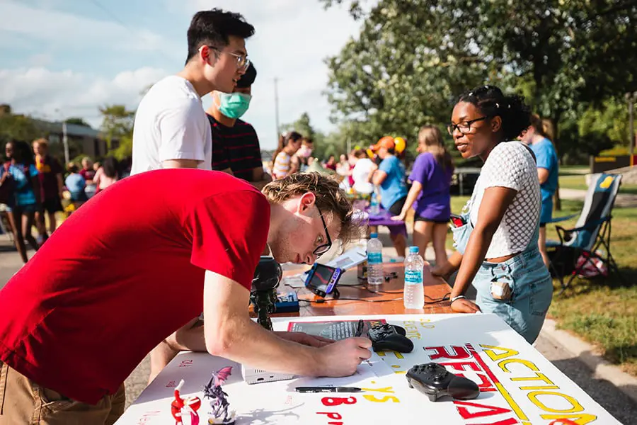 Students on campus painting posters