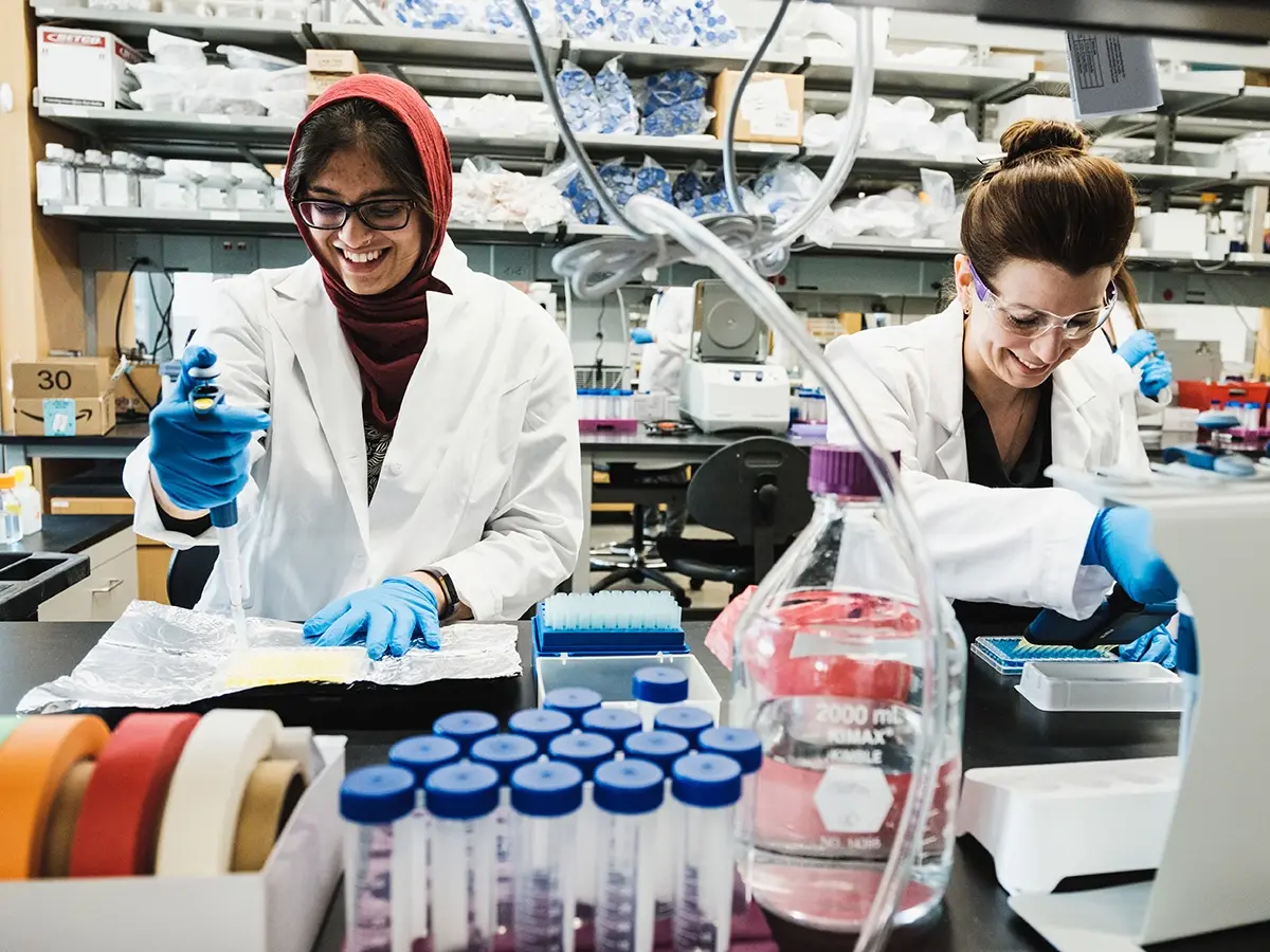 Two students conduct research in a lab on campus.
