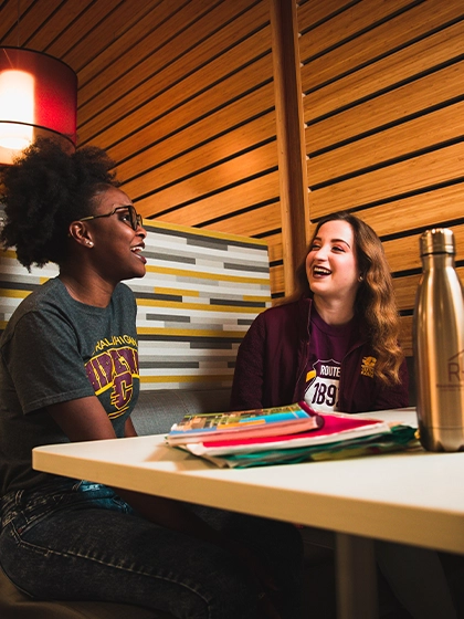 Two students sitting in a residential restaurant on campus.