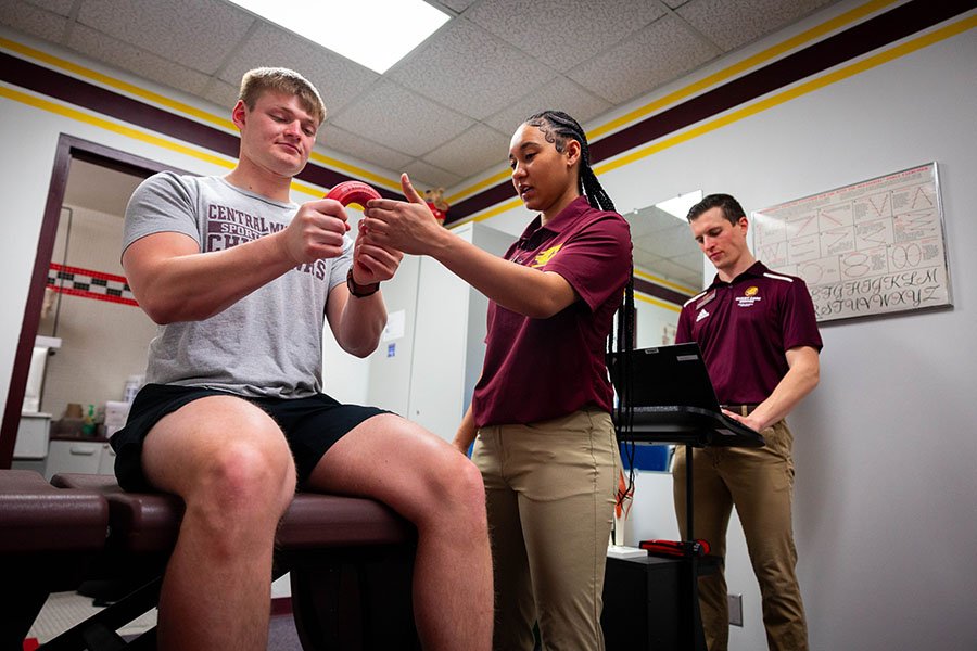 Two therapy students help a patient regain their strength and ability to take part in normal activities after an injury.