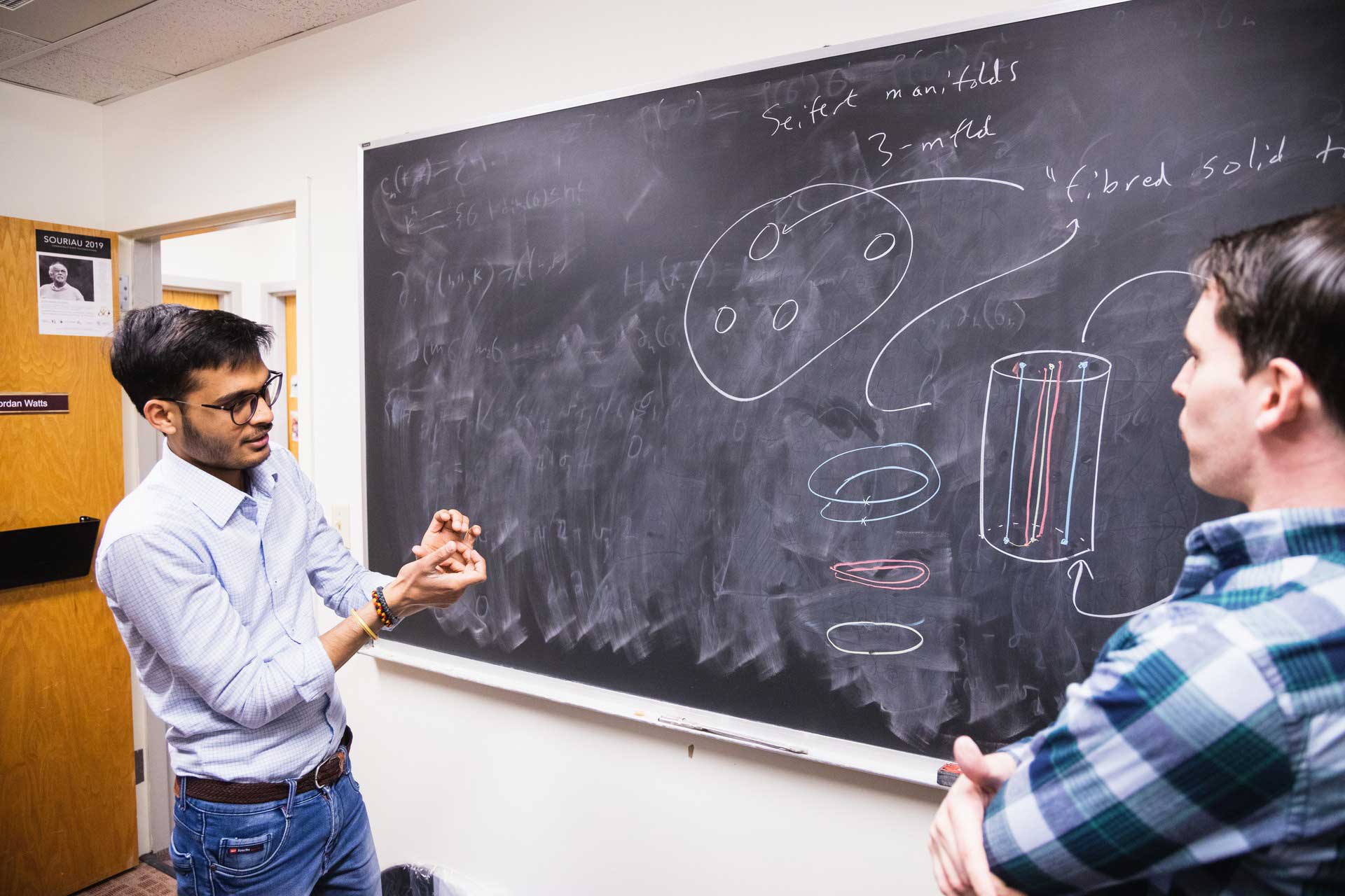 Students discussing at a blackboard