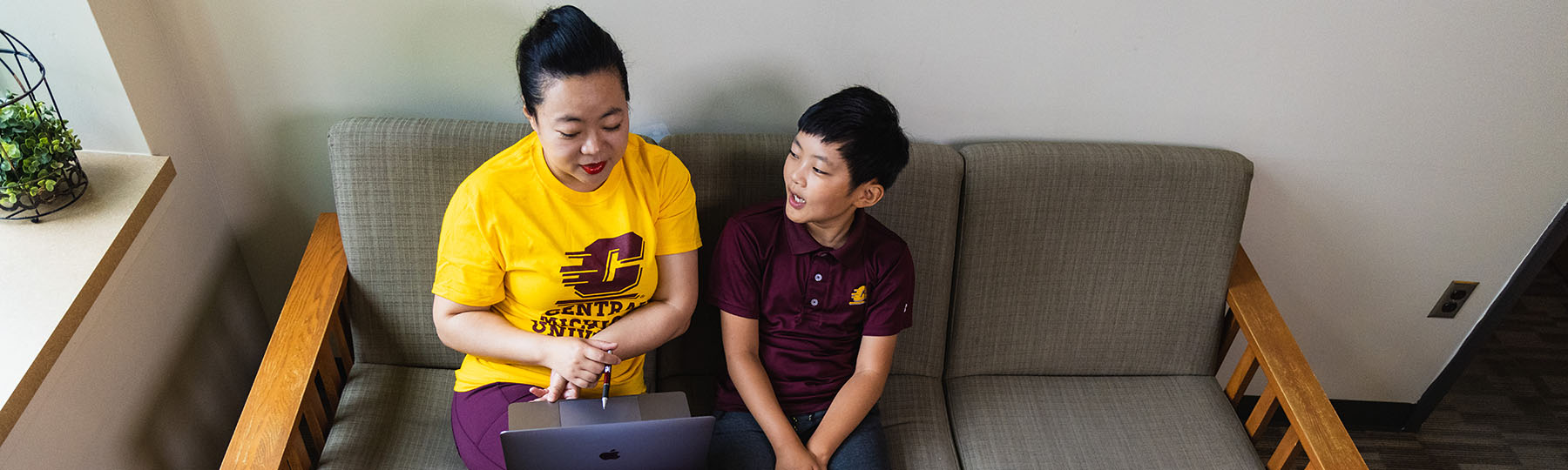 Mother shows her online homework to her son
