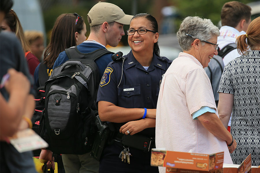 Police Officer L. Martinez smiles while surrounded by others who are walking by during CMU's Get Acquainted Day.