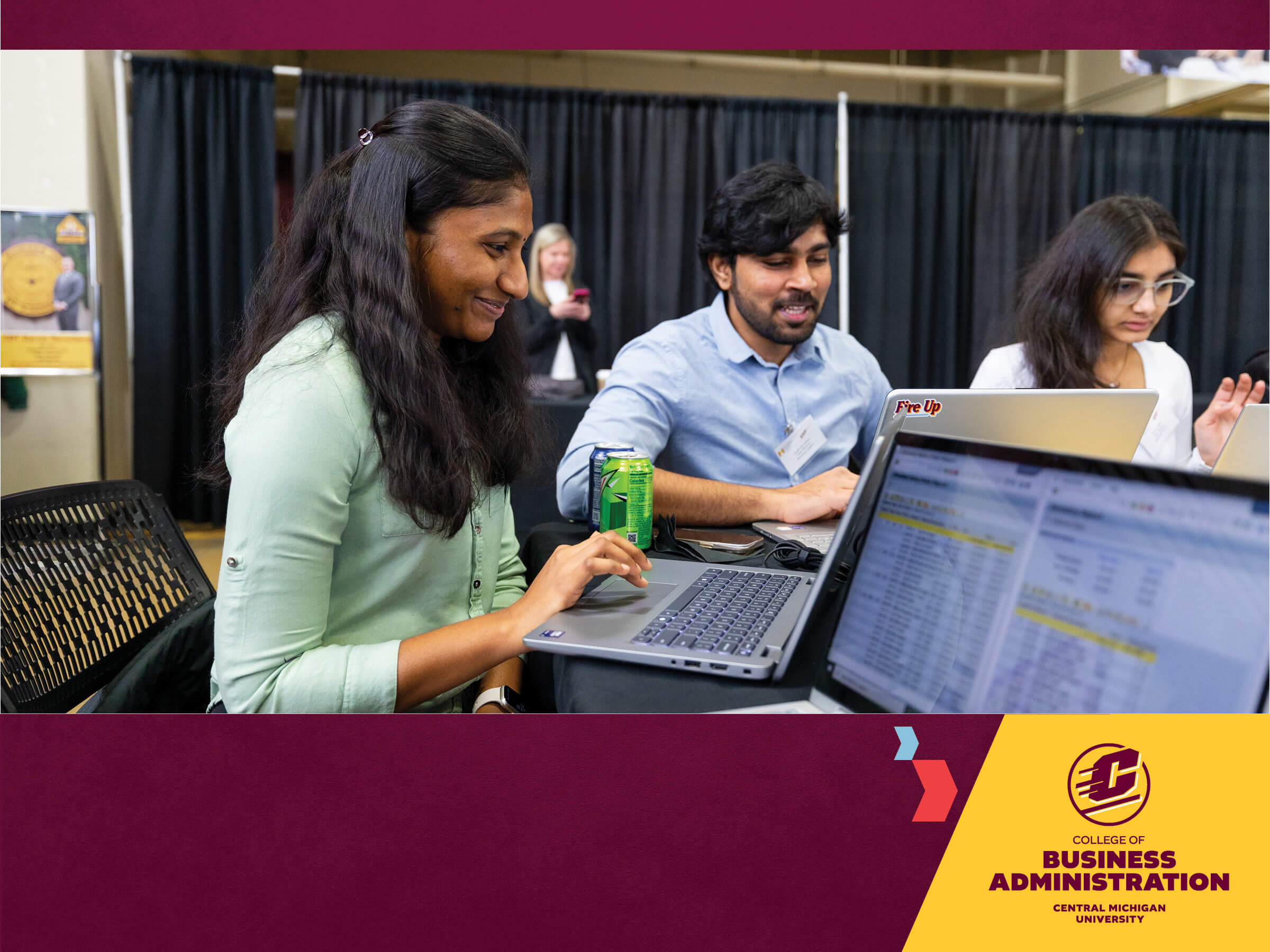 PowerPoint Standard CBA_2026 a group of students sitting at a table looking at a laptop