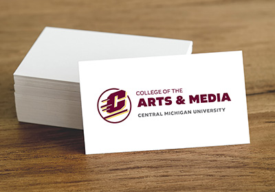 CMU lockup with the words "College of Arts and Media" in maroon and "Central Michigan University" in small gray type below, the Action C within a circle on the right, all placed on a white business card.