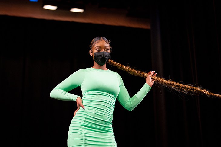 A model shows off their outfit and hair onstage at the OBU Fashion Show.