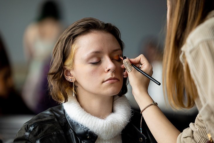 A student model gets their makeup ready for the 2022 Threads Fashion Show on Saturday, April 2.
