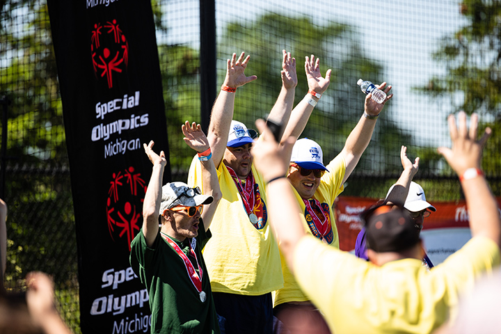 Special Olympics Michigan athletes celebrate on the awards stand during the 2022 State Summer Games.