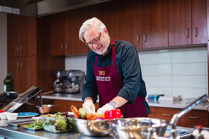 Associate Professor of Dietetics, Jeffrey Fisher, makes gluten free spring rolls inside CMU's Wightman Hall.