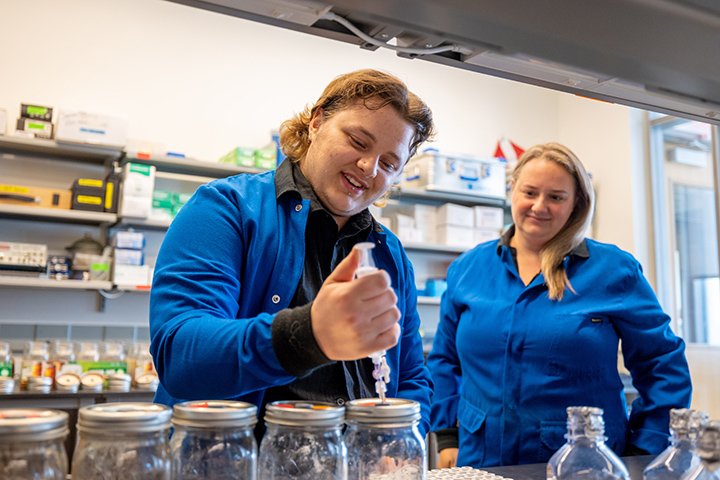 Post doctoral researcher Amanda Suchy McNair (right) and their mentee, Braxton, test  soil samples in The Biosciences Building.