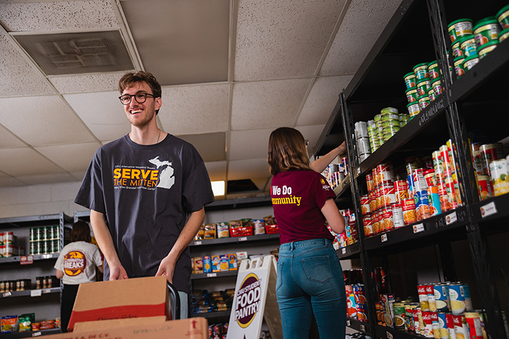 CMU Food Pantry summer employee Matthew Thomas helps keep the shelves stocked.