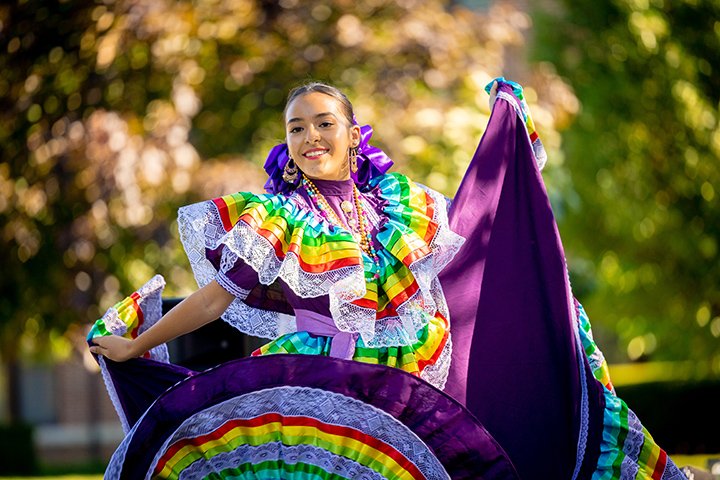 A student in a beautiful rainbow-colored dress dances during Get Acquainted Day.