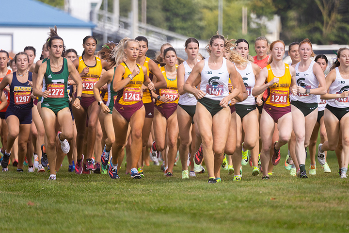 Dozen's of women's cross country athletes run in a pack.