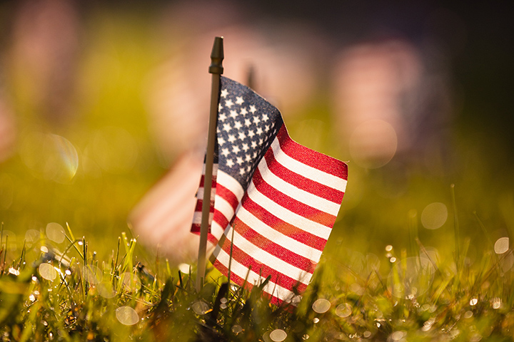 A small American flag is planted in the ground.