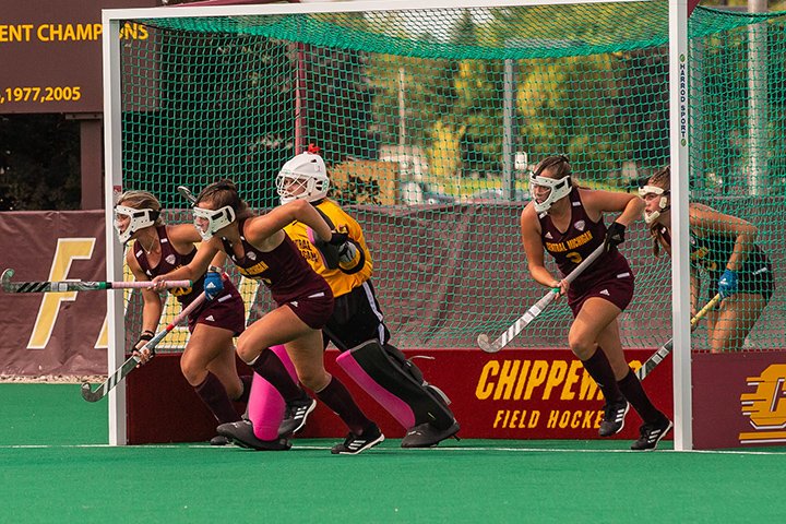 CMU field hockey players run out of their net.