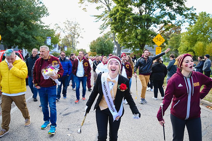 A female student wearing a sash reading 