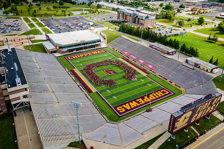 Students from Leadership Safari and the CMU Marching Band form a “C” on the turf inside Kelly/Shorts Stadium.