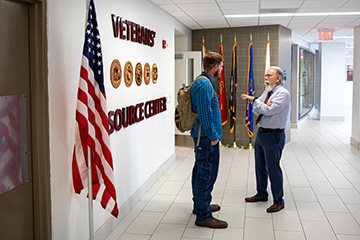 Two people talk in the hallway outside of the CMU Veterans' Resource Center.