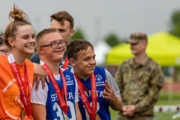 Special Olympics Michigan athletes pose for a photo on the awards stand during the 2019 State Summer Games.