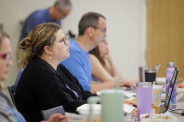 A woman listens to a presentation about how to use artificial intelligence to teach writing.