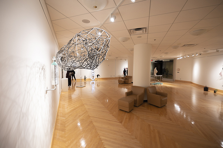 A silver egg-shaped art piece is displayed on the wall in the Charles V. Park Library.
