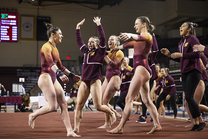 Members of the CMU women's gymnastics team celebrate after defeating Eastern Michigan.