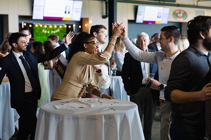 A group of medical students high-five each other in celebration.