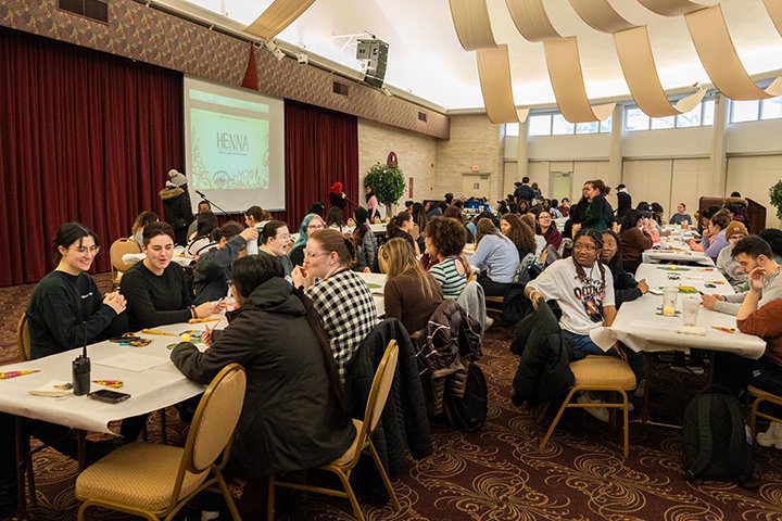 Dozens of students sit at tables for a South Asian cultural event.