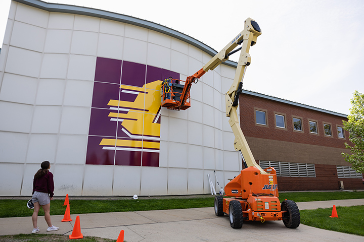 A large CMU logo gets installed on the side of the Industrial and Engineering Technology Building.
