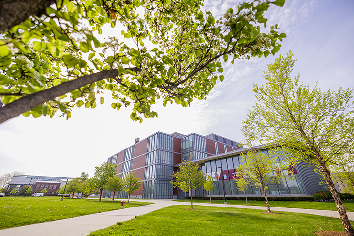 A wide angle shot of the Dow Science Building with green trees in the foreground.