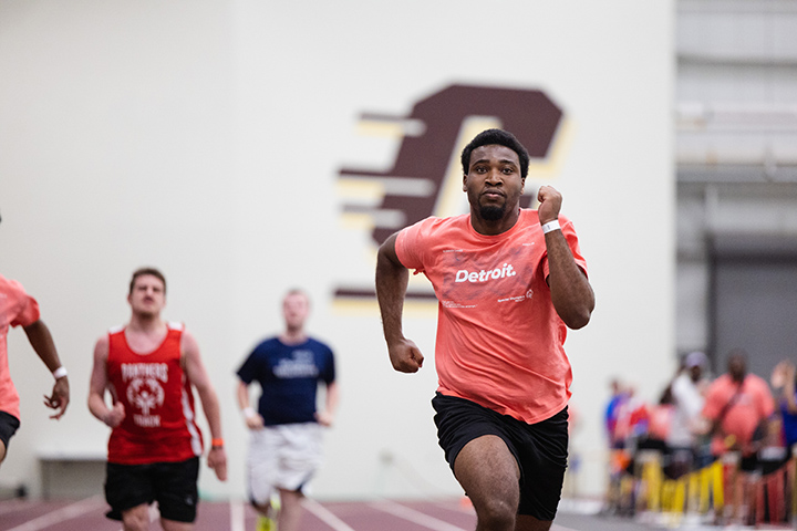 Special Olympics Michigan athletes run down the track inside CMU's IAC.