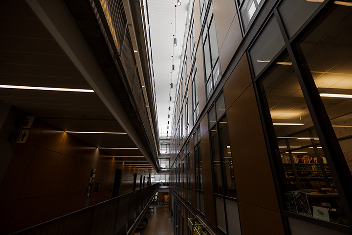 A long, dark corridor with many windows inside the Biosciences Building.