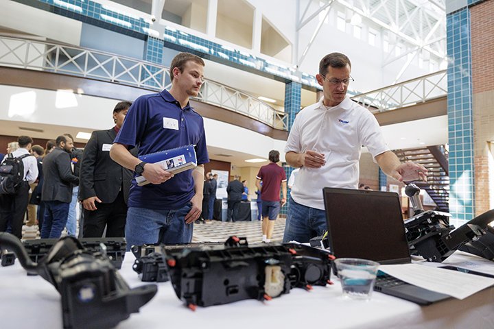 Inside a large common area with natural light, CMU students speak with potential employers during a STEM job and internship fair.