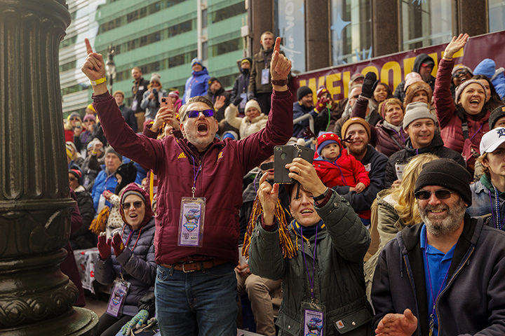 CMU friends and supporters cheer from the stands in downtown Detroit along the parade route.